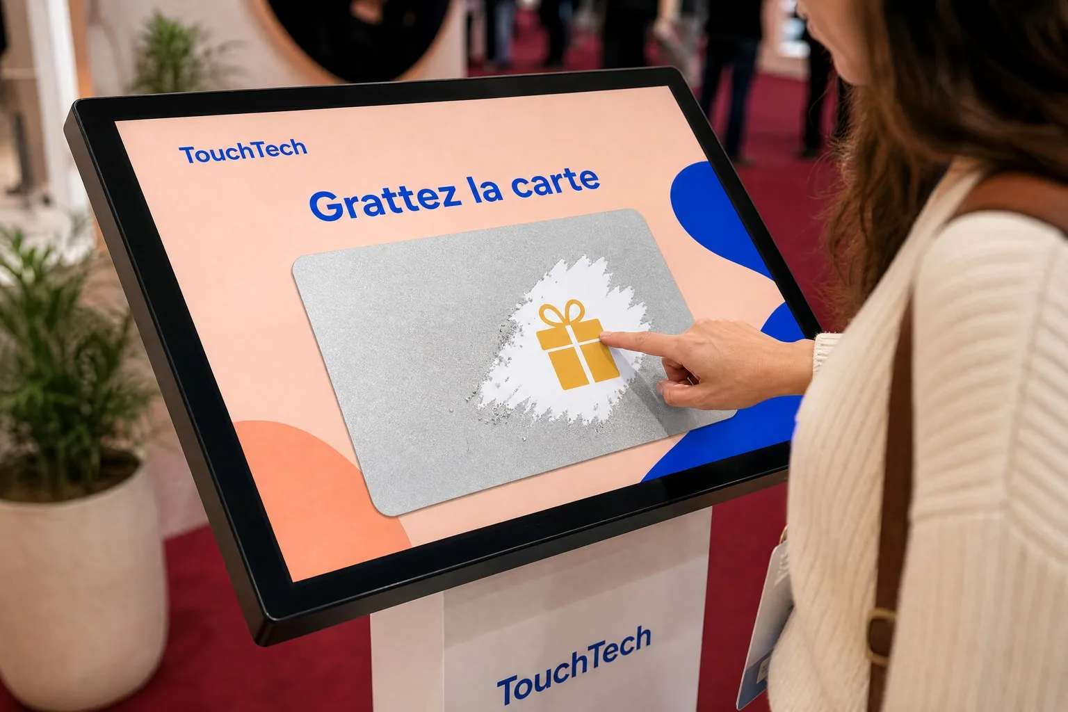 Gros plan : du bout du doigt, la visiteuse gratte la carte et découvre un cadeau.
